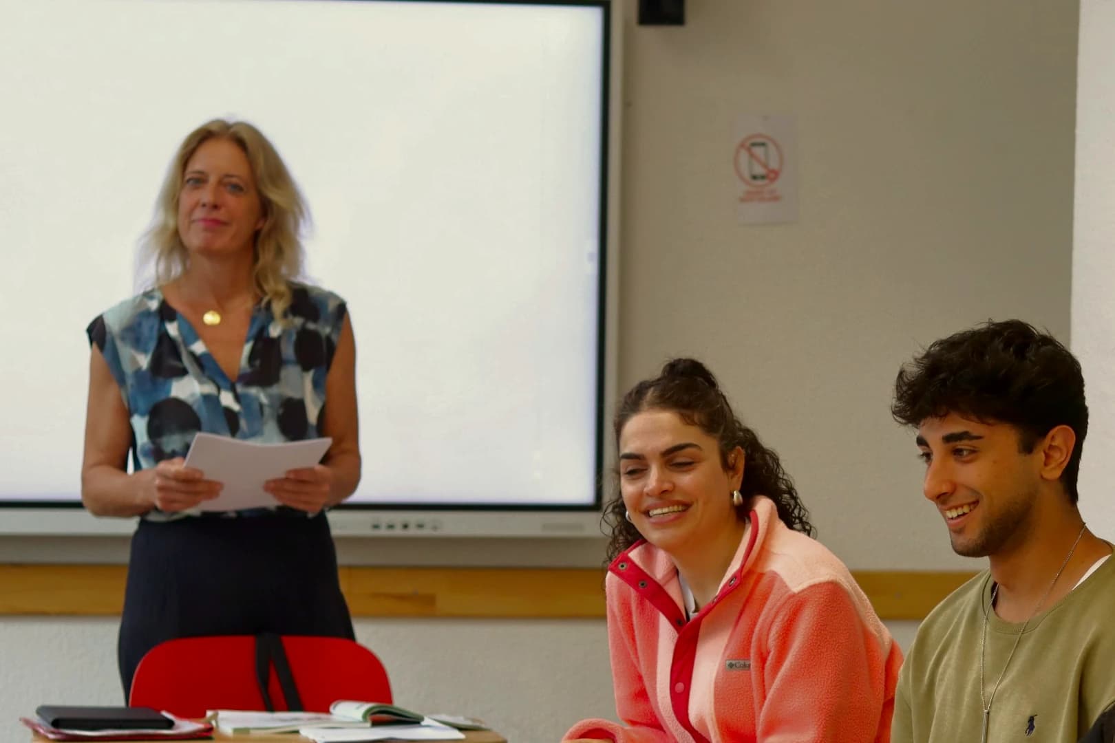 Eine Lehrerin und lächelnde Teilnehmende im Unterricht